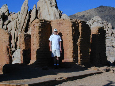 Andy standing by old adobe walls